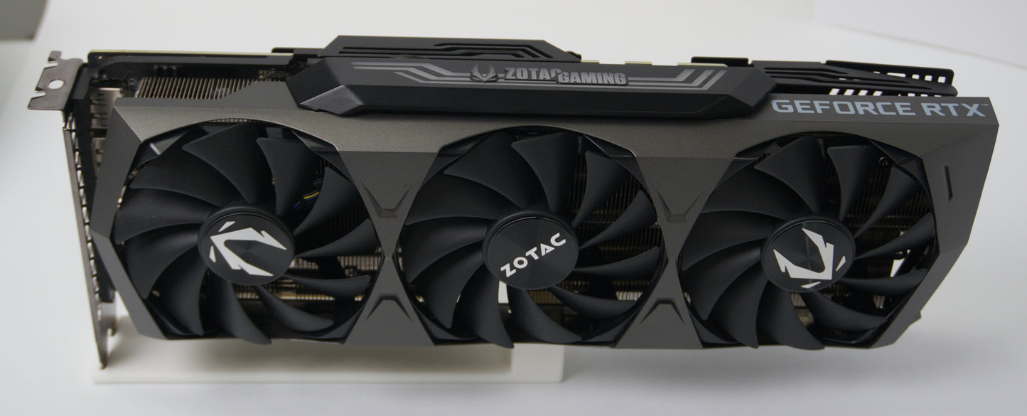 Zotac GeForce RTX graphics card with a triple-fan cooling system, shown from a front-three-quarter angle on a white surface.
