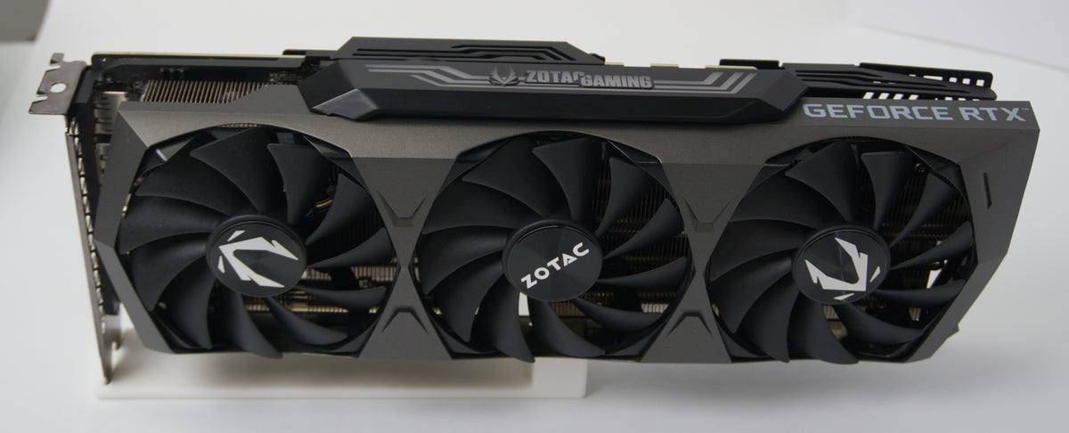 Zotac GeForce RTX graphics card with a triple-fan cooling system, shown from a front-three-quarter angle on a white surface.