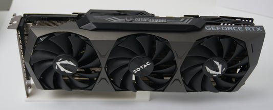 Zotac GeForce RTX graphics card with a triple-fan cooling system, shown from a front-three-quarter angle on a white surface.